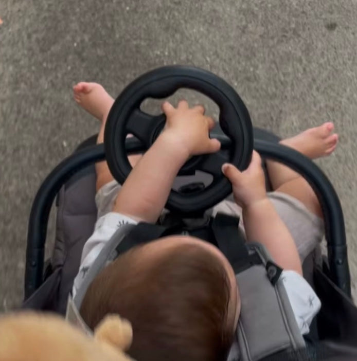 Child using the steering wheel on a stroller ride