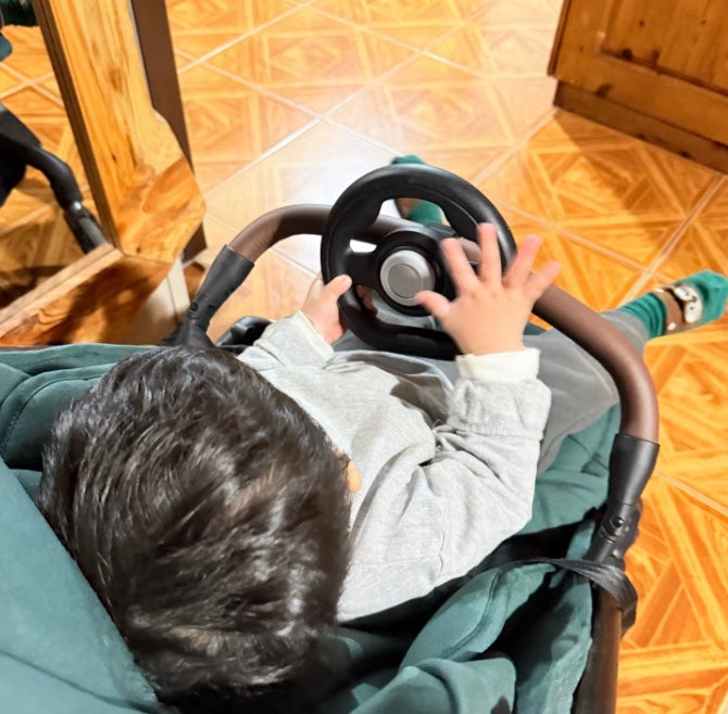 Child playing with the stroller steering wheel